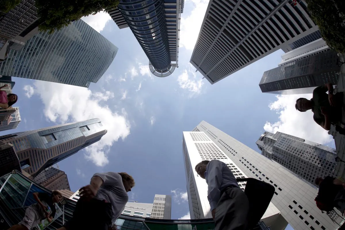 People walk past office buildings at the central business district in Singapore on April 14, 2015. (Edgar Su/Reuters)