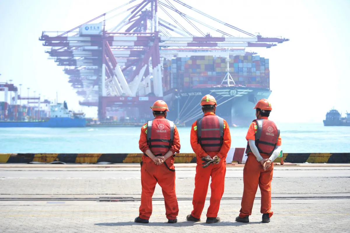 Workers stand at the port of Qingdao, Shandong Province, China on June 10, 2019. (Reuters)