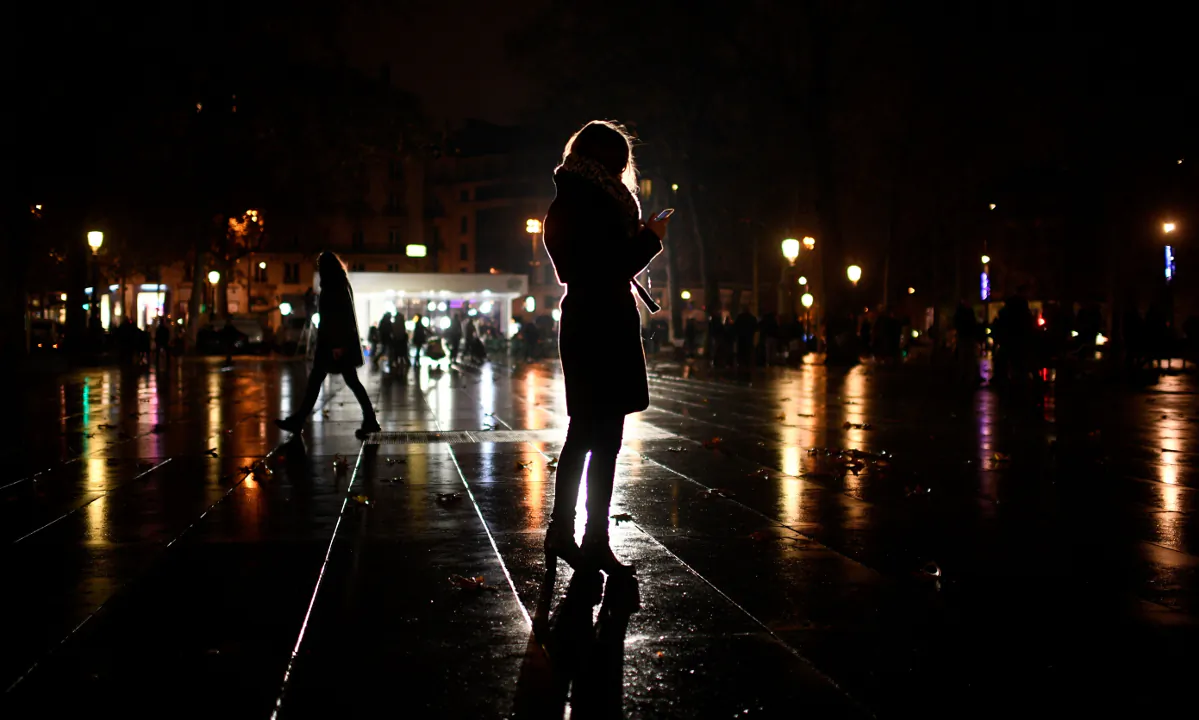 A woman on a phone at night. (Martin Bureau/AFP/Getty Images)