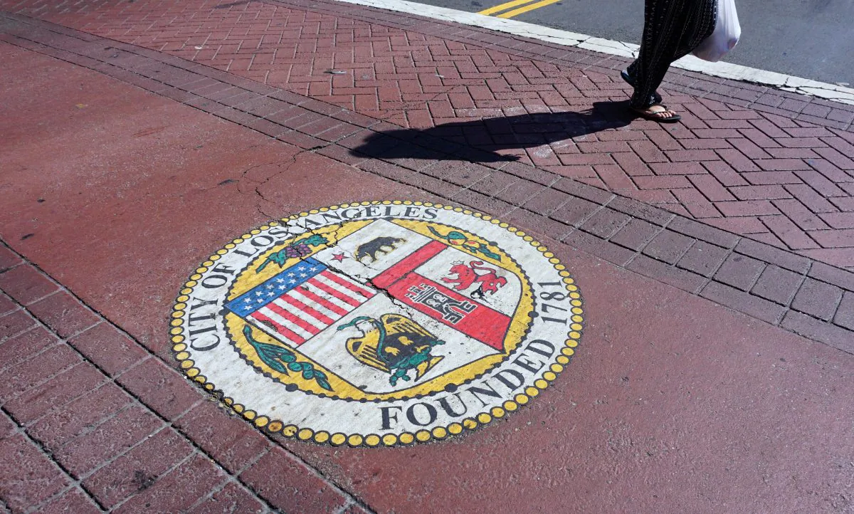 A woman crosses a street in front of City Hall in Los Angeles on Aug. 22, 2017. 
(FREDERIC J. BROWN/AFP/Getty Images)
