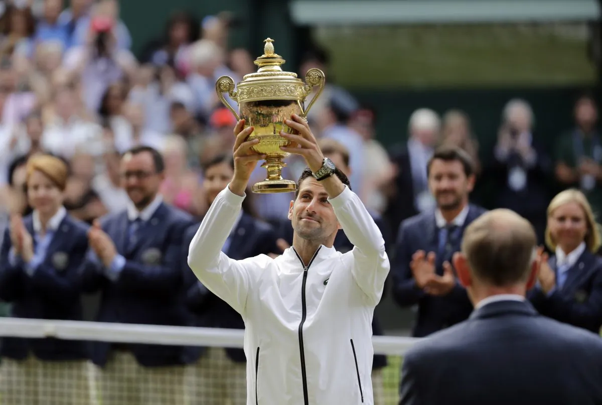 Serbia's Novak Djokovic lifts his trophy after defeating Switzerland's Roger Federer during the men's singles final match of the Wimbledon Tennis Championships in London, on July 14, 2019. (Ben Curtis/AP Photo)