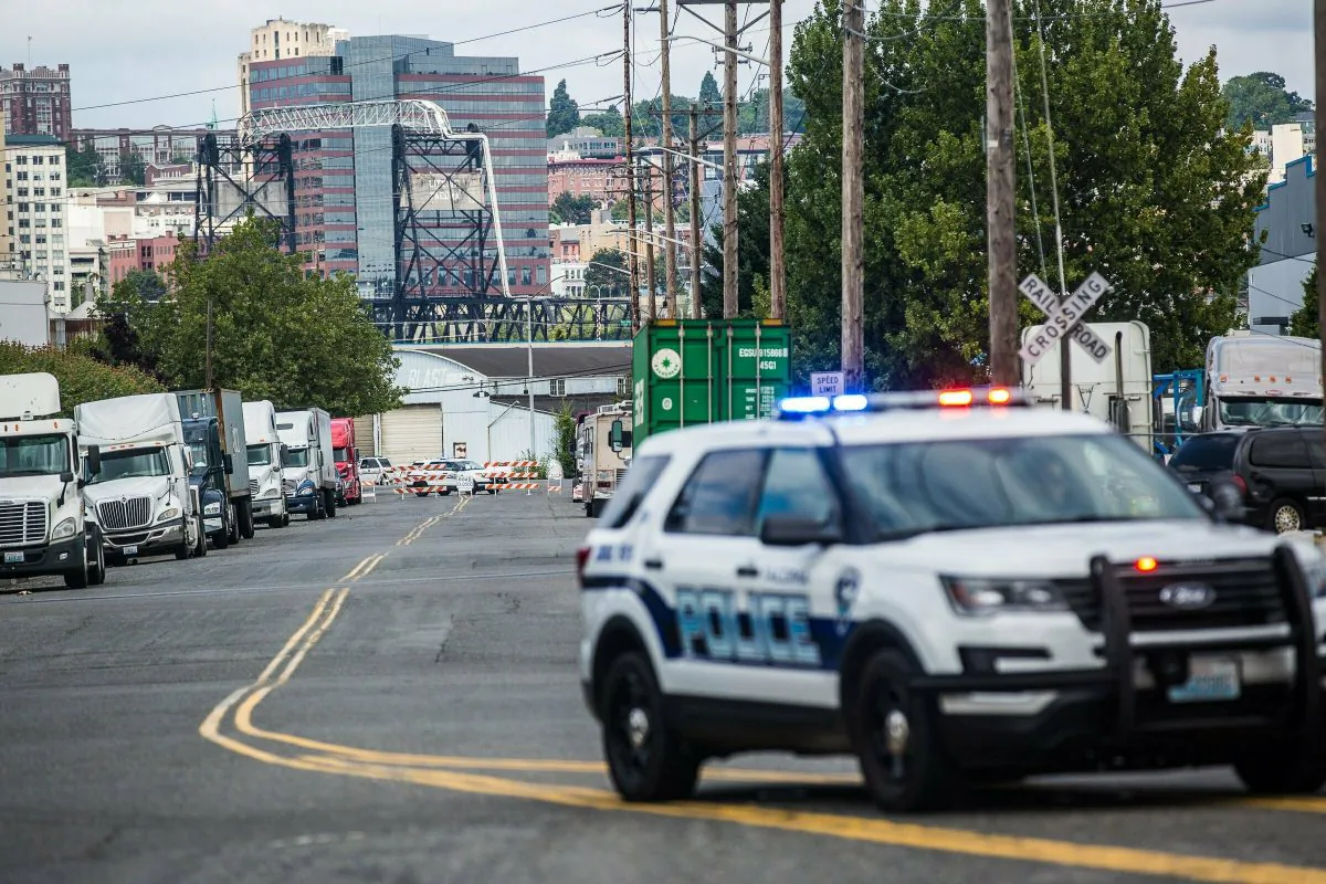 A police officer guards the front of a road block near the Northwest Detention Center in Tacoma, Wash. on July 13, 2019. (Rebekah Welch/The Seattle Times via AP)