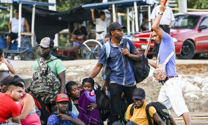 A group of 10 Haitians illegally cross the Suchiate River on a tube raft from Tecun Uman, Guatemala, to Hidalgo City, Mexico, on June 28, 2019. Many traveled through Colombia, Panama, Costa Rica, Nicaragua, and Honduras to get this far. (Charlotte Cuthbertson/The Epoch Times)