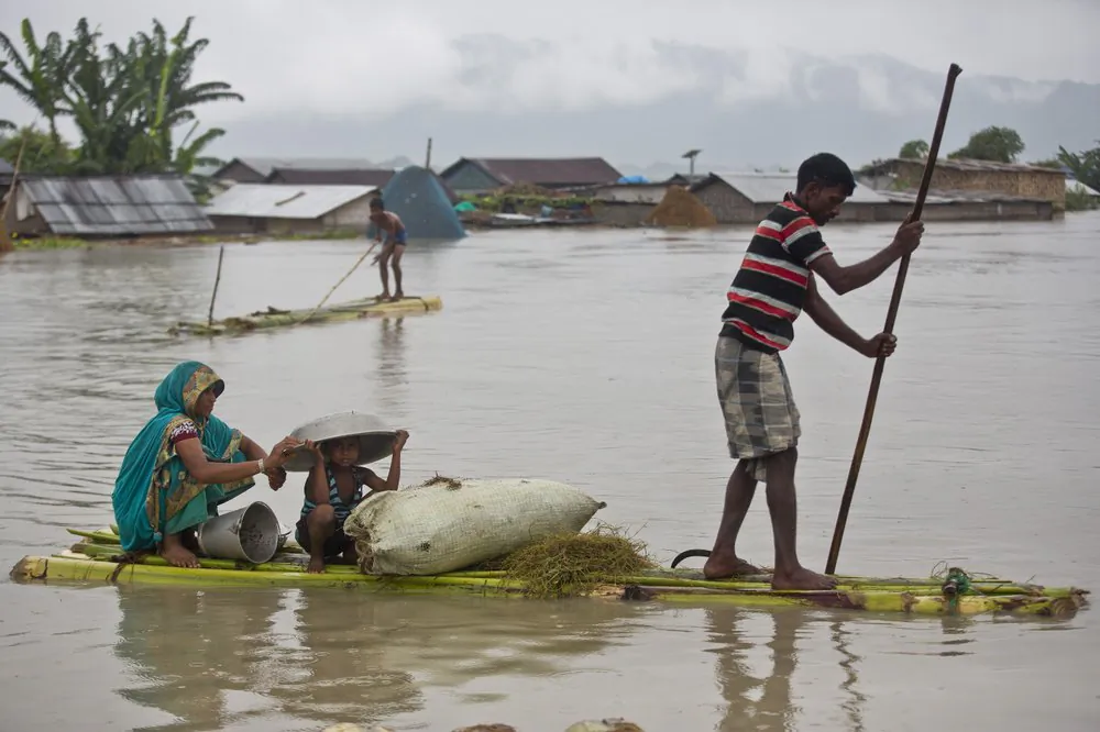 Flood effected villagers move on a makeshift bamboo raft in Katahguri village along the river Brahmaputra, east of Gauhati, India on July 14, 2019. (Anupam Nath/AP)