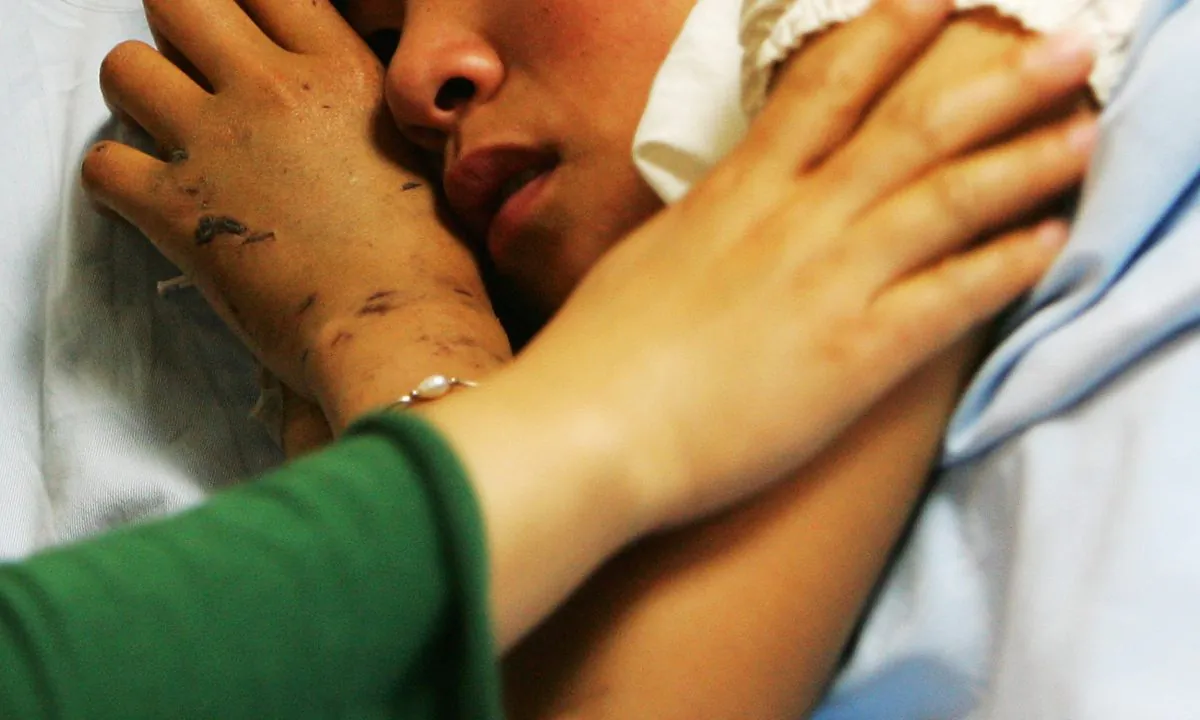 A girl laying in a hospital bed in China. (Guang Niu/Getty Images)
