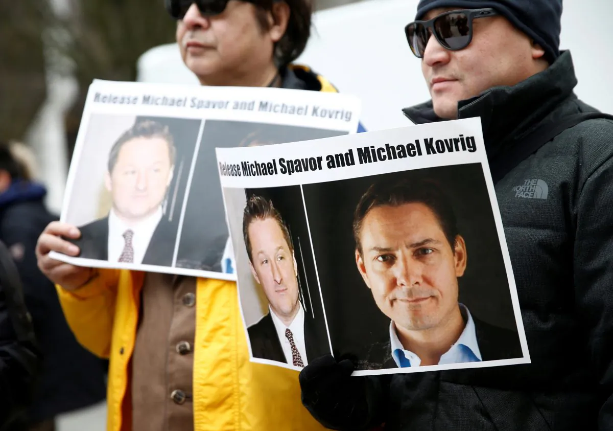 People hold signs calling for China to release Canadians Michael Spavor and Michael Kovrig during an extradition hearing for Huawei executive Meng Wanzhou at the B.C. Supreme Court in Vancouver on March 6, 2019. (Lindsey Wasson/Reuters)