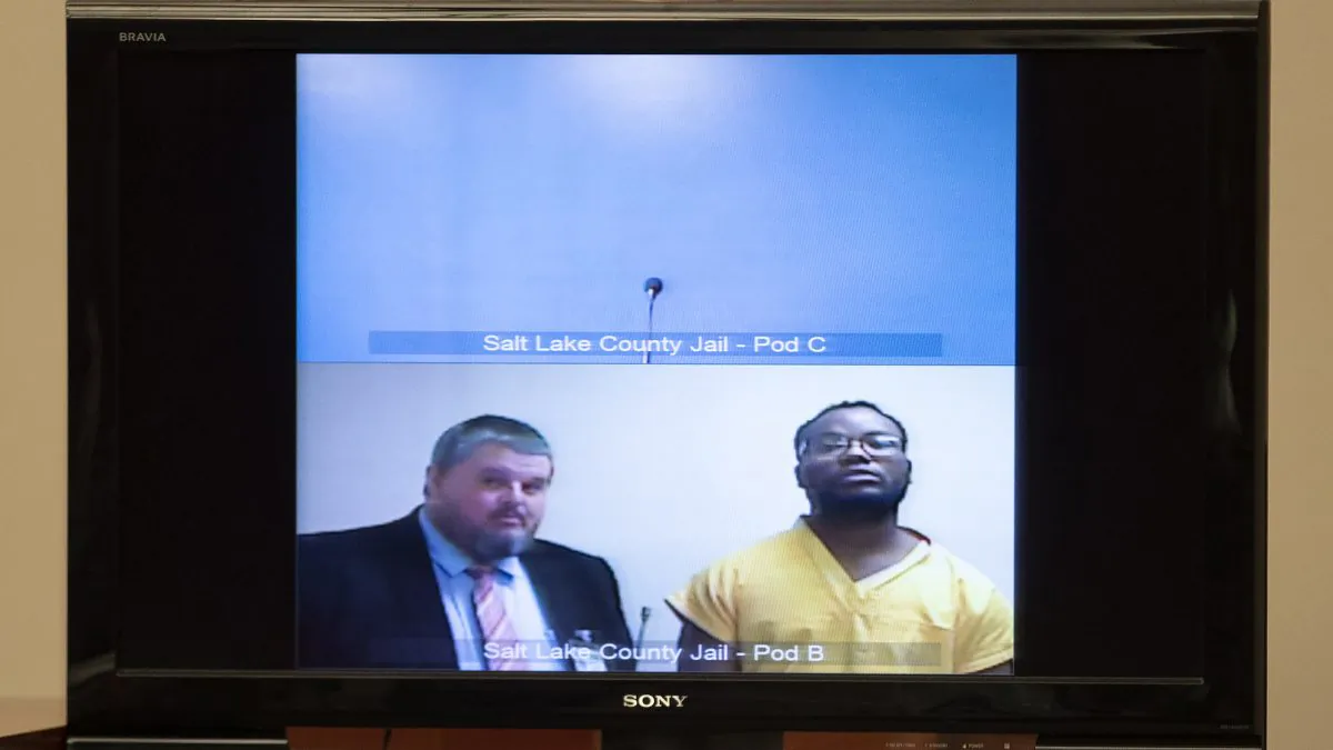 Attorney Neal Hamilton, left, stands with Ayoola A. Ajayi during his video preliminary hearing at the Matheson Courthouse on July 15, 2019, in Salt Lake City. (Steve Griffin/Deseret News, via AP Photo, Pool)