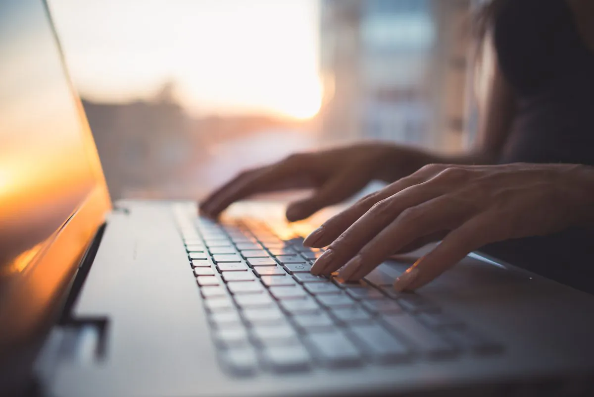 Woman working at home office hand on keyboard close up. (Undrey/Shutterstock)
