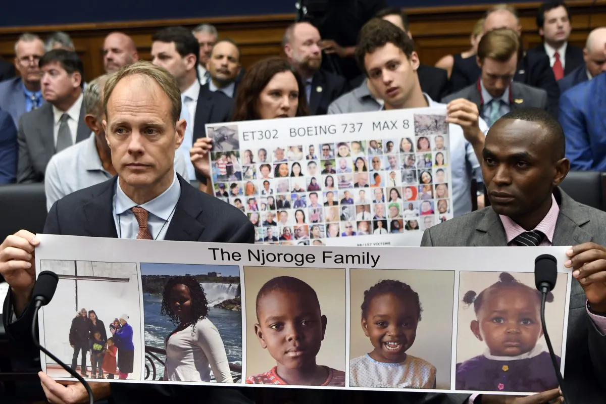 Michael Stumo, left, and Paul Njoroge, right, hold up photos of the Njoroge family before the start of a House Transportation subcommittee hearing on Capitol Hill in Washington, July 17, 2019, on aviation safety. (AP Photo/Susan Walsh/The Canadian Press)