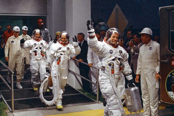 Neil Armstrong, Michael Collins and Buzz Aldrin walk to the van