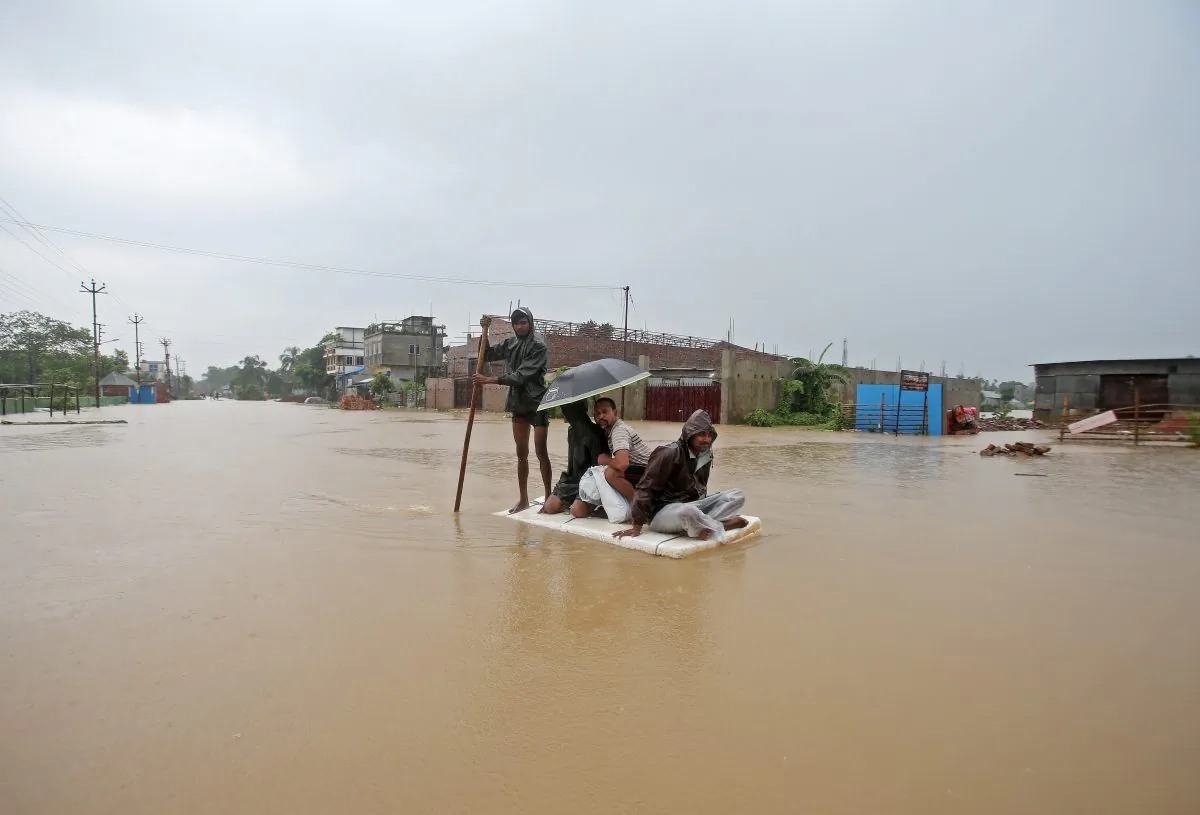 Villagers use a makeshift raft to cross a flooded area on the outskirts of Agartala, India on July 15, 2019. (Jayanta Dey/Reuters)