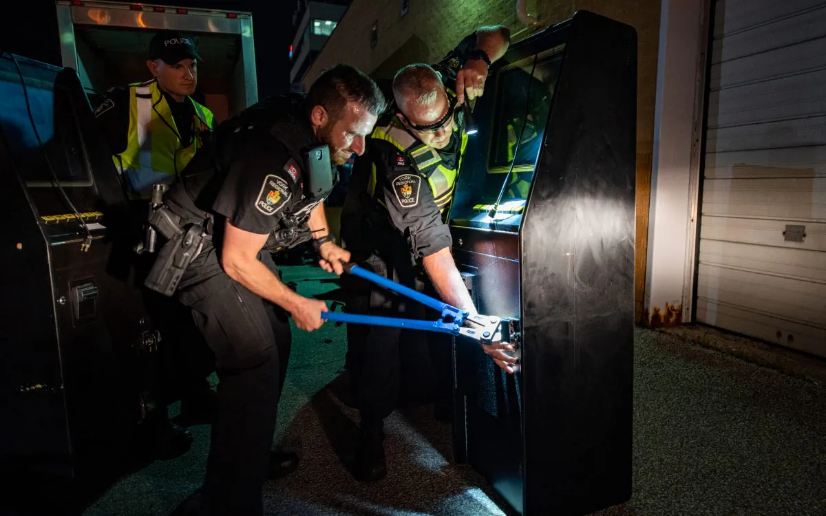 Officers with the York Regional Police work on dismantling a gaming machine at a mafia-owned location as part of a massive organized crime raid on July 12, 2019. (York Regional Police)