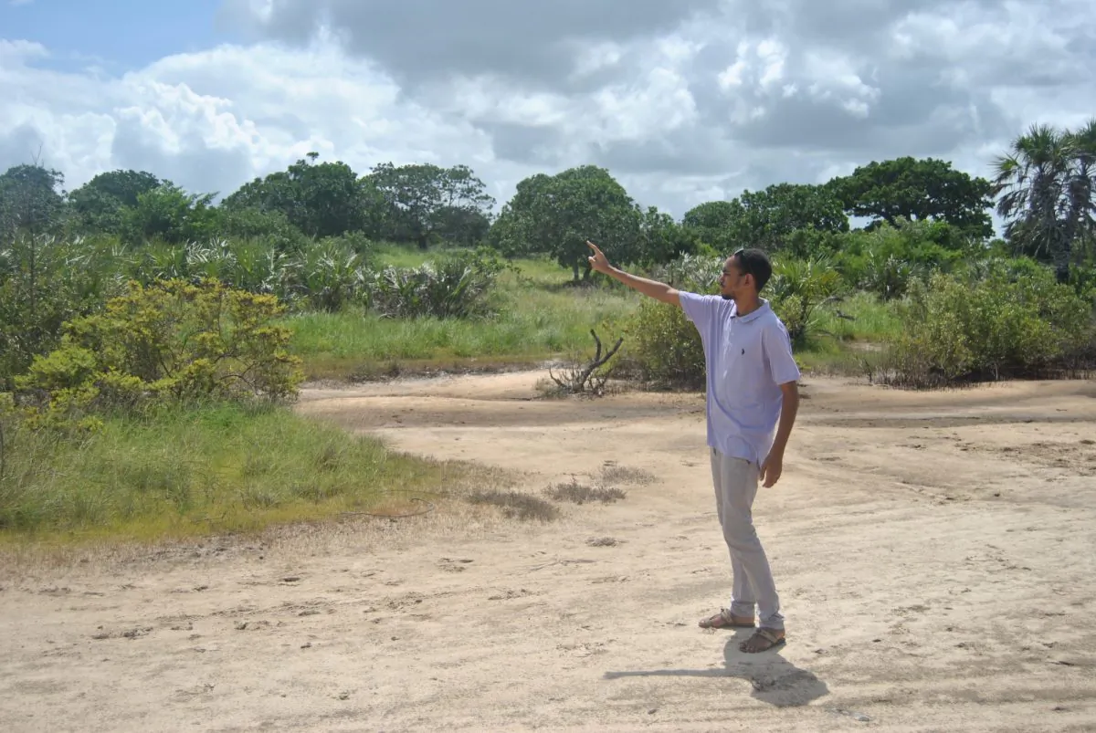 Swaleh Elbusaidy, a community environmental lawyer at Save Lamu, points into the distance to explain effects of the coal plant on the environment while standing at the proposed site for the coal plant on July 10, 2019. (Dominic Kirui for The Epoch Times)