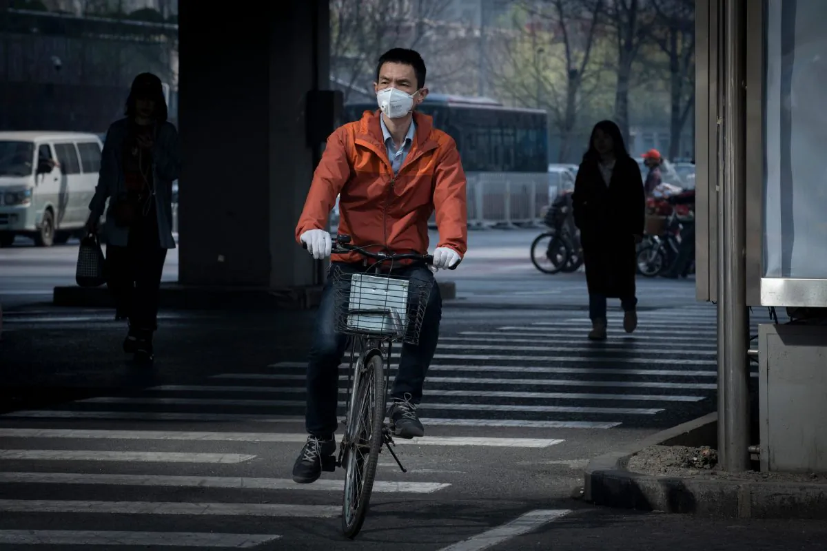 A man riding a bicycle wears a protective mask to reduce the effects of air pollution in Beijing on March 27, 2019. (Nicolas Asfouri/AFP/Getty Images)