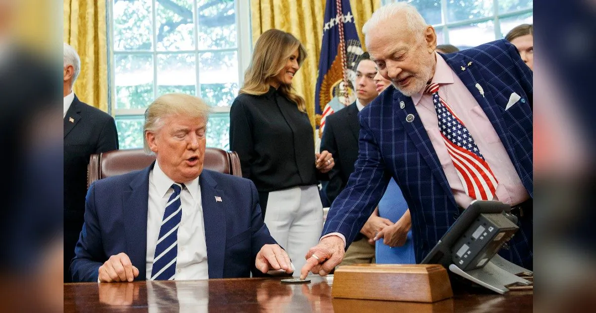 President Donald Trump receives a gift from Apollo 11 astronaut Buzz Aldrin, with first lady Melania Trump, during a photo opportunity commemorating the 50th anniversary of the Apollo 11 moon landing in the Oval Office of the White House, Friday, July 19, 2019, in Washington. (AP Photo/Alex Brandon)