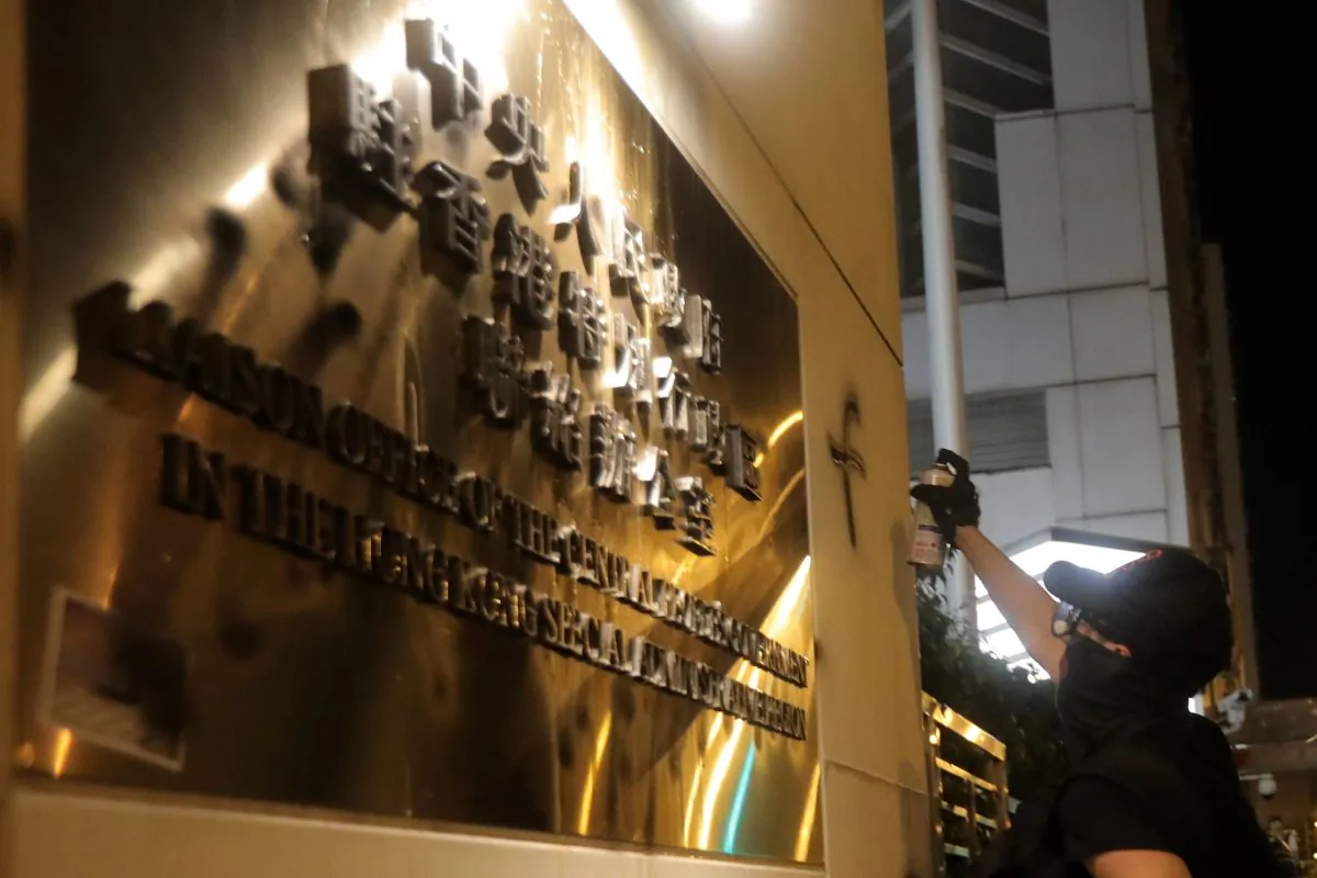 A protester sprays graffiti next to a sign for the Beijing liaison office after a march against a controversial extradition bill in Hong Kong on July 21, 2019. (VIVEK PRAKASH/AFP/Getty Images)