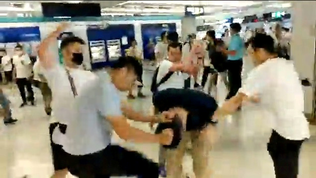 Men in white T-shirts and face masks attack anti-extradition bill demonstrators and reporters at a train station in Hong Kong, on July 21, 2019, in this still image obtained from a social media live video. (Courtesy of Stand News/Social Media via Reuters)
