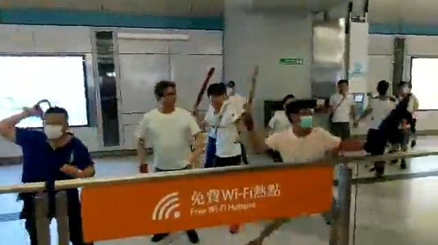 Men in white t-shirts and face masks attack anti-extradition bill demonstrators and reporters at a train station in Hong Kong, China, July 21, 2019, in this still image obtained from a social media live video. Courtesy of Stand News/Social Media via REUTERS