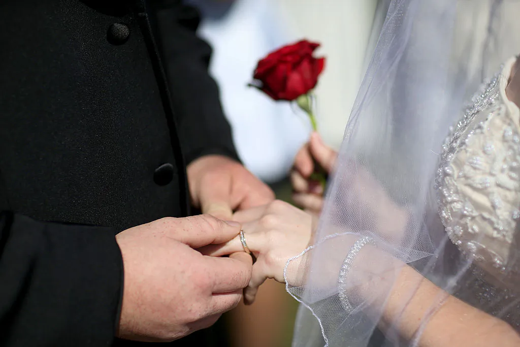A couple exchanges rings during their marriage ceremony. (Photo by Joe Raedle/Getty Images)