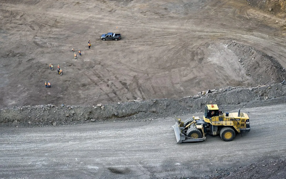 Workers survey the base of the 500-foot-deep open pit at Molycorp's Mountain Pass Rare Earth facility in Mountain Pass, Calif., on June 29, 2015. (David Becker/Reuters)