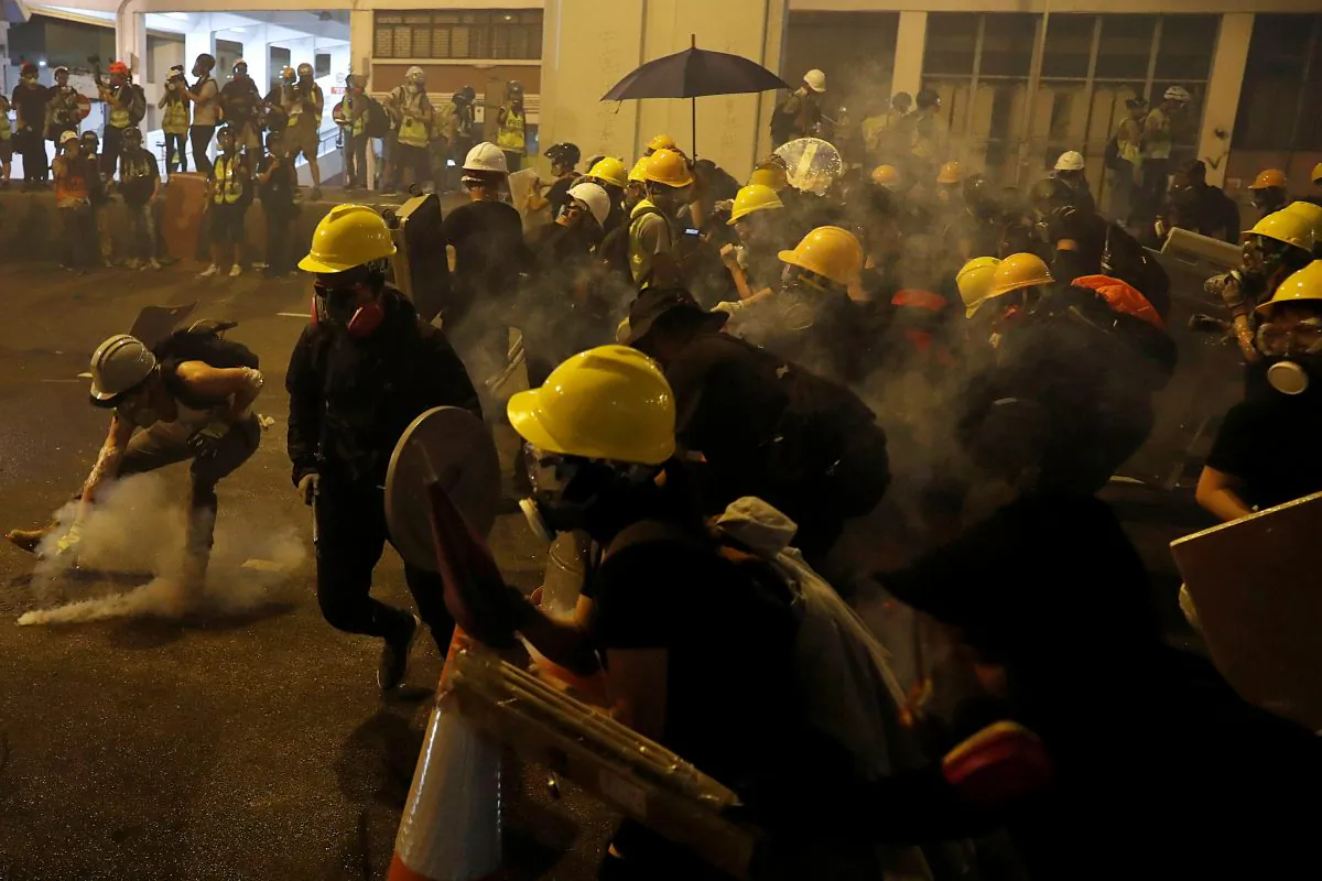 An anti-extradition bill protester picks up a tear gas canister during clashes with riot police after a march to call for democratic reforms, in Hong Kong, on July 21, 2019. (Tyrone Siu/Reuters)