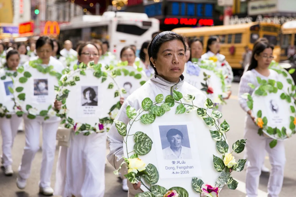 Falun Gong practitioners hold wreaths with photos of people who were killed inside China for their beliefs during a parade in New York City on May 12, 2017. (Samira Bouaou/The Epoch Times)