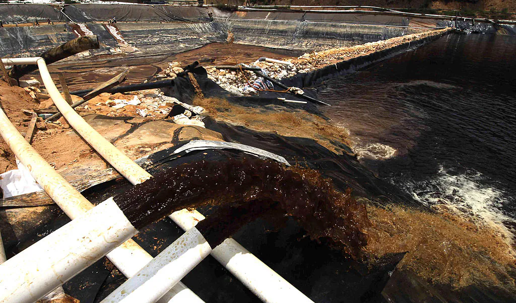 Workers drain away polluted water near the Zijin copper mine in Shanghang after pollution from the mine contaminated the Ting river, a major waterway in southeast China's Fujian Province, on July 13, 2010. (STR/AFP/Getty Images)
