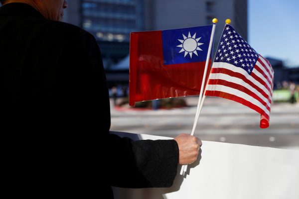 FILE PHOTO: A demonstrator holds flags of Taiwan and the United States in support of Taiwanese President Tsai Ing-wen during an stop-over after her visit to Latin America in Burlingame