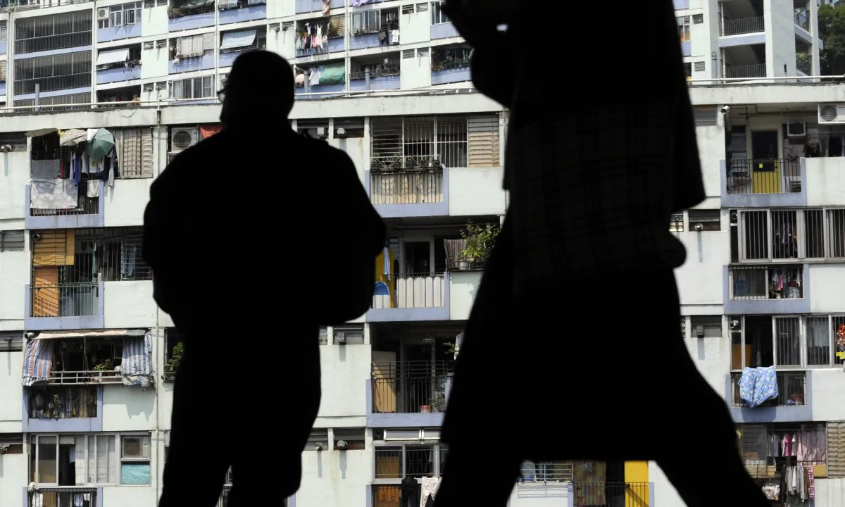 A man's silhouette against apartments in China. (Antony Dickson/AFP/Getty Images)