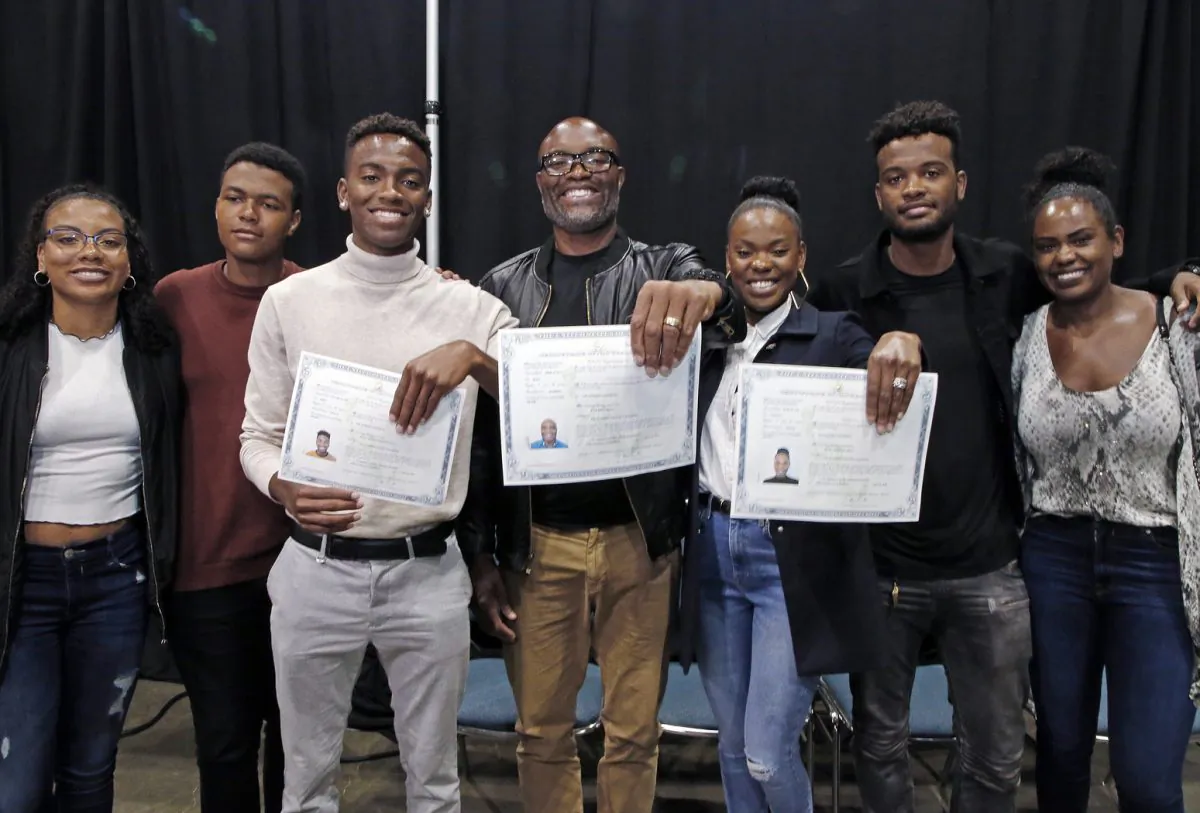 Mixed martial arts great Anderson "Spider" Silva of Brazil (C), his daughter Kaory, 23 (R), and son Kalyl, 20 (L), hold their citizenship documents after they are sworn in as U.S. citizens in a mass naturalization ceremony on July 23, 2019 at the Los Angeles Convention Center. (Reed Saxon/AP)