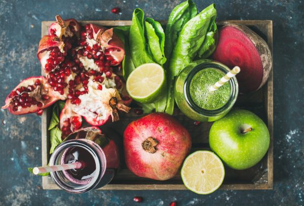 Green and purple fresh juices or smoothies with fruit, greens, vegetables