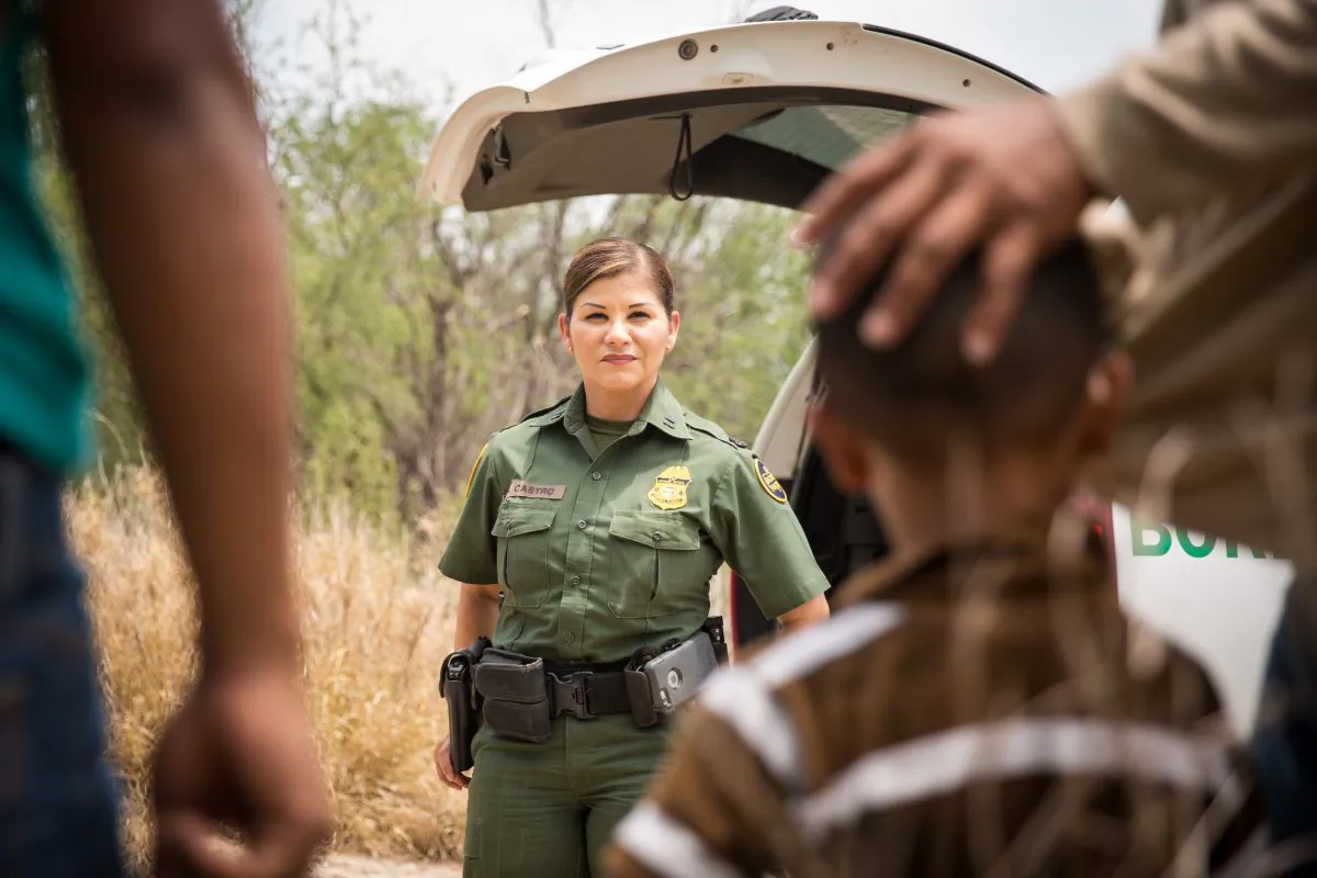 Supervisory Border Patrol agent Marlene Castro speaks to a group of illegal aliens who just crossed the Rio Grande from Mexico into the United States in Hidalgo County, Texas, on May 26, 2017. (Benjamin Chasteen/The Epoch Times)