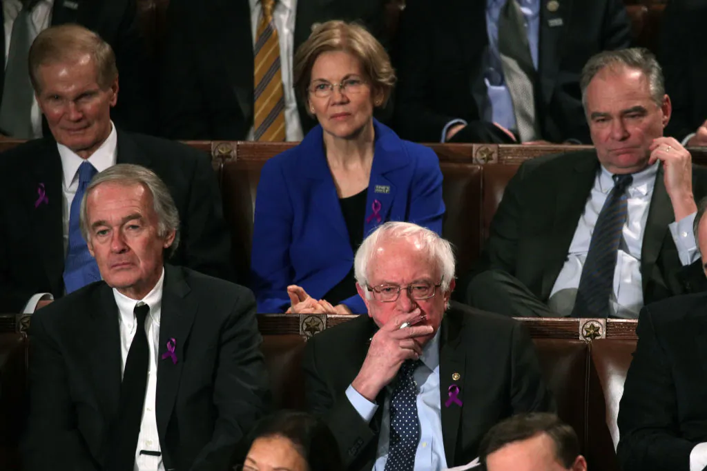 Sens. Elizabeth Warren (D-Mass.) and Bernie Sanders (I-VT) (C) watch during the State of the Union address in the chamber of the U.S. House of Representatives in Washington, on Jan. 30, 2018. (Alex Wong/Getty Images)