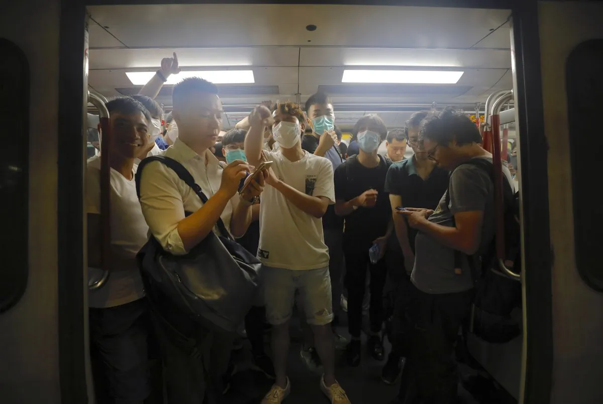 Protesters wearing masks occupy a train car at a subway station in Hong Kong on July 30, 2019. Protesters in Hong Kong have disrupted subway service during the morning commute by blocking the doors on trains, preventing them from leaving the stations. (Vincent Yu/AP)