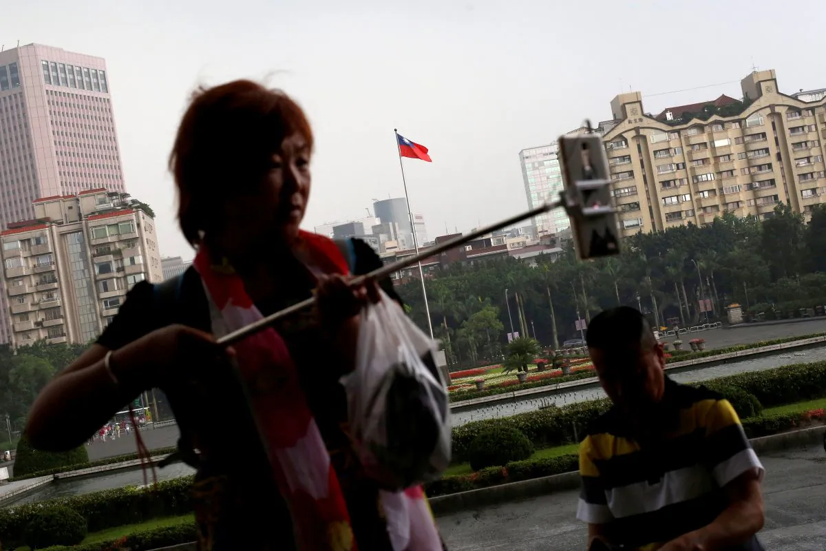 A tourist from China takes a selfie in front of a Taiwanese flag, in Taipei, Taiwan on May 5, 2016. (Tyrone Siu/Reuters)