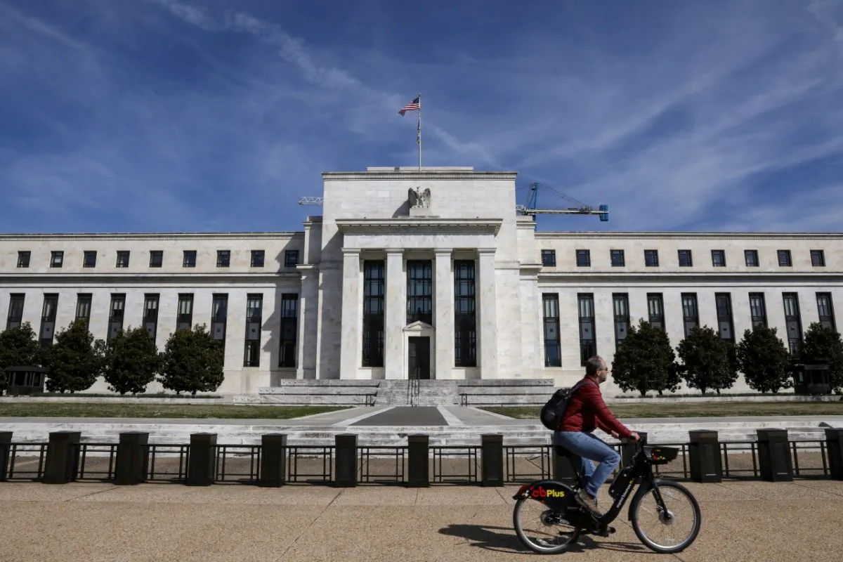 A man rides a bike in front of the Federal Reserve Board building on Constitution Avenue in Washington on March 27, 2019. (Brendan McDermid/Reuters)