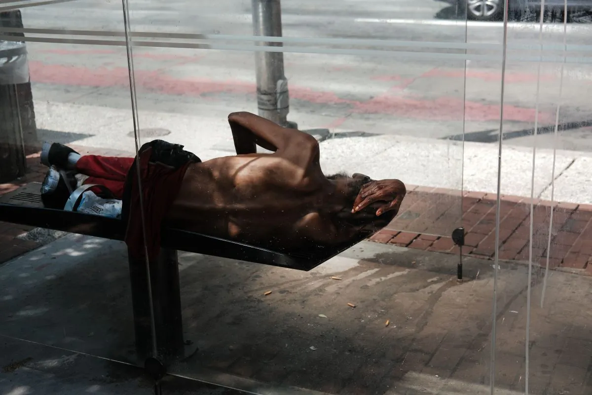 A man sleeps on a bench in downtown on July 28, 2019 in Baltimore, Maryland. (Spencer Platt/Getty Images)