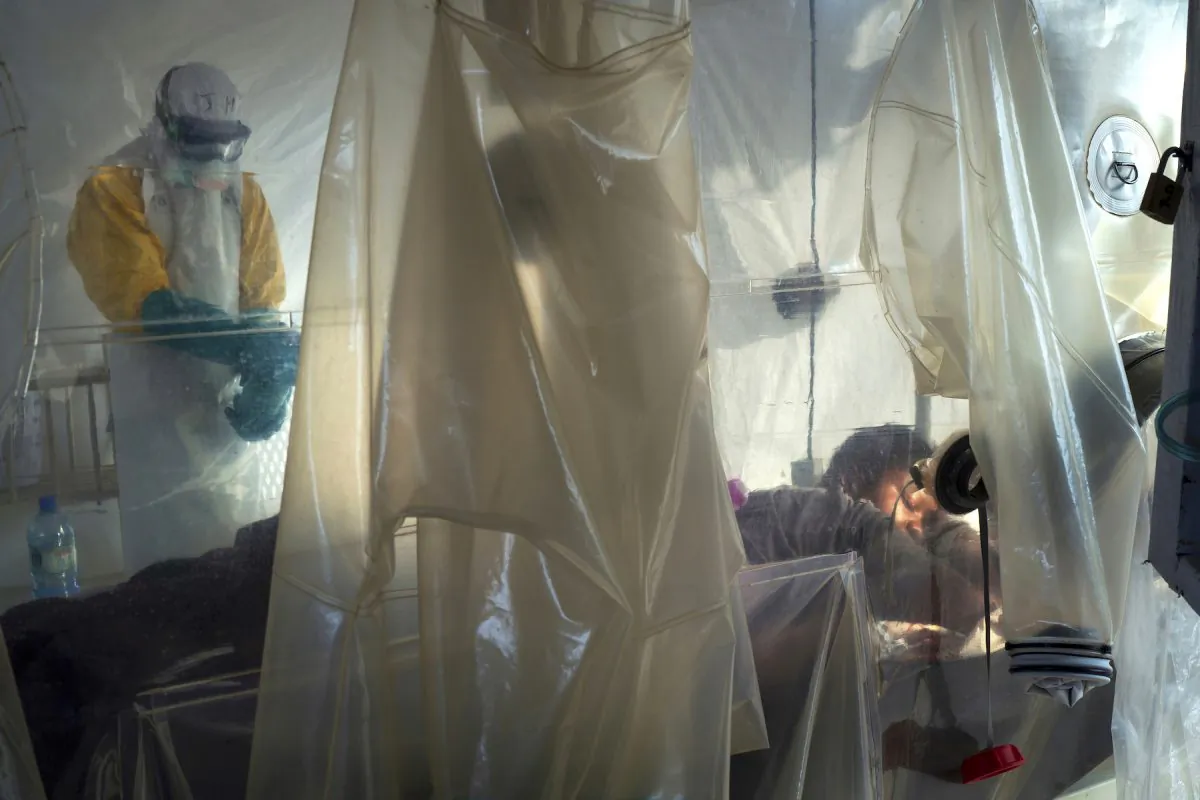 Health workers dressed in protective gear check on a patient isolated in a plastic cube at an Ebola treatment center in Beni, Congo DRC onJuly 13, 2019. (AP Photo/Jerome Delay)