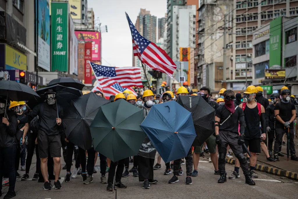 Protesters hold up umbrellas and American flags in the face of advancing riot police in the district of Yuen Long in Hong Kong on July 27, 2019. (Laurel Chor/Getty Images)