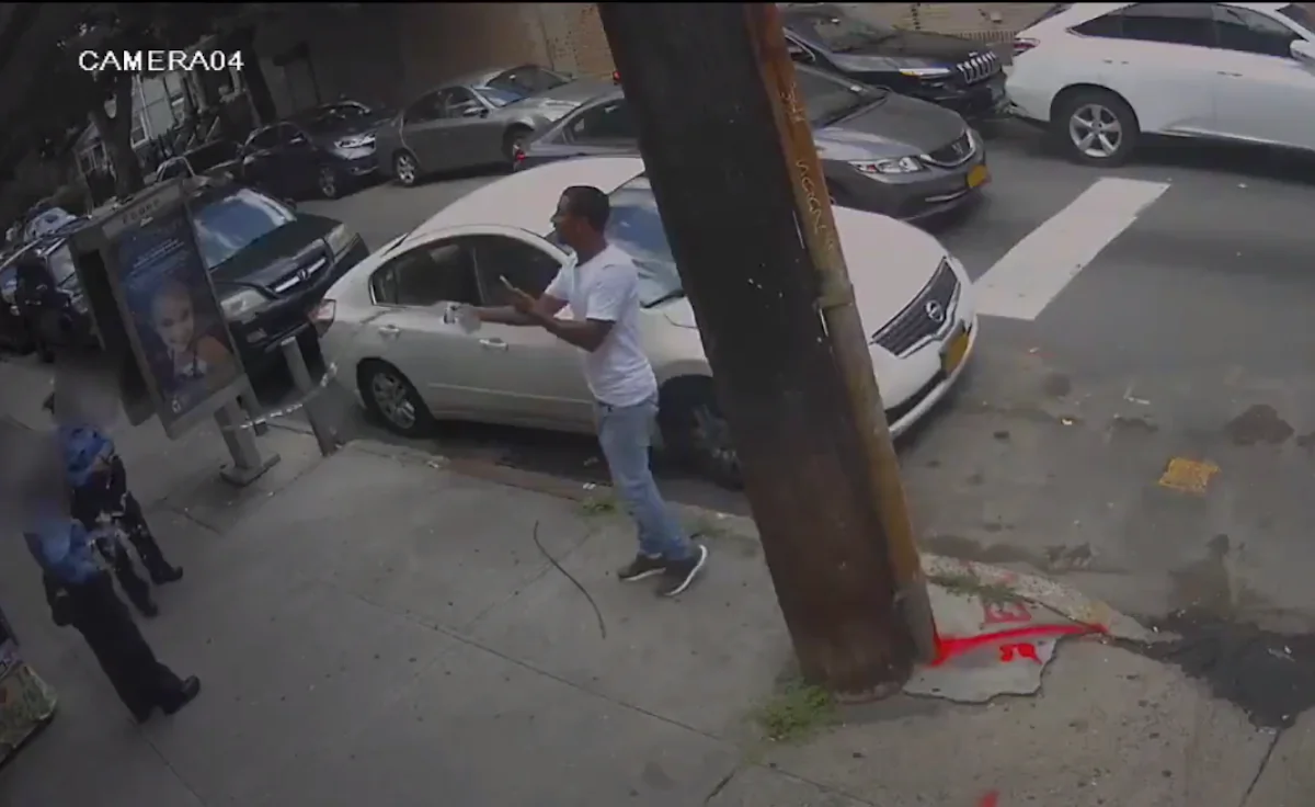 Two traffic officers were standing near Jamaica Avenue and 86th Street on July 24 afternoon when a man walked over and sprayed water on them. (Screenshot/NYPD Crime Stoppers)