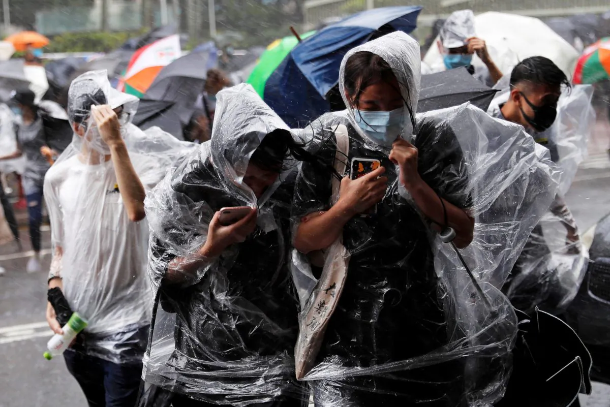 People react under heavy rain as typhoon Wipha approaches in Hong Kong, China on July 31, 2019. (Tyrone Siu/Reuters)
