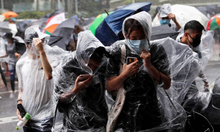 People react under heavy rain as typhoon Wipha approaches in Hong Kong, China on July 31, 2019. (Tyrone Siu/Reuters)
