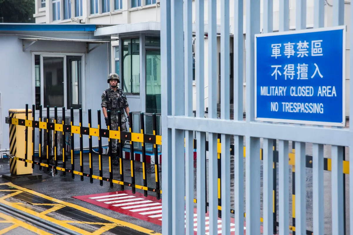 A Chinese People's Liberation Army (PLA) soldier guards the entrance to the PLA Forces Hong Kong Building, which is the headquarters for the PLA Hong Kong Garrison, in the Admiralty district in Hong Kong on August 1, 2019. (ISAAC LAWRENCE/AFP/Getty Images)
