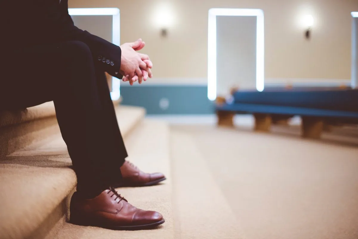 Stock photo of a man sitting down on a bench. (Ben White/Unsplash)