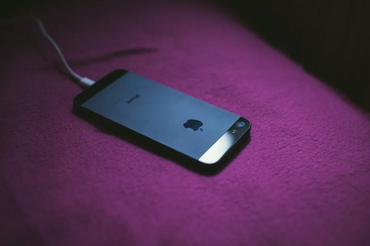 A stock photo shows an iPhone being charged in bed. (Pixabay)