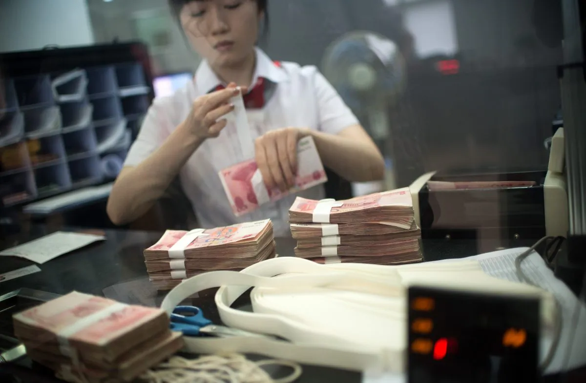 A worker of an Industrial and Commercial Bank of China Ltd (ICBC) branch counts money as she serves a customer in the China (Shanghai) Pilot Free Trade zone during a media trip on  Sept. 24, 2014. (Johannes Eisele/AFP/Getty Images)
