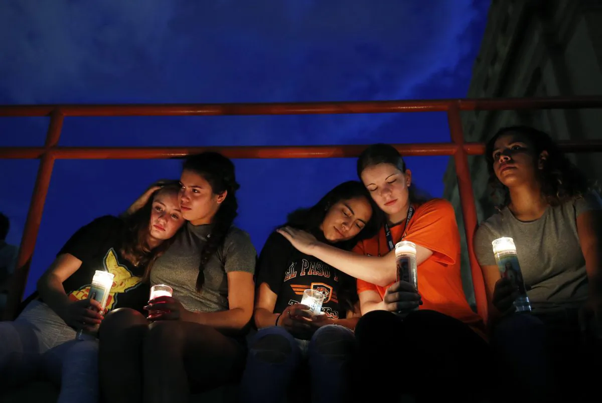 People comfort each other during a vigil for victims of the mass shooting in El Paso, Texas, on Aug. 3, 2019. (AP Photo/John Locher)