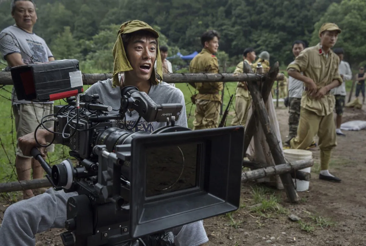 A Chinese cinematographer wears a Japanese army hat during the filming of the series “The Last Noble,” set during the second Sino-Japanese War in Fangyan, China, on Aug. 13, 2015.  (Kevin Frayer/Getty Images)