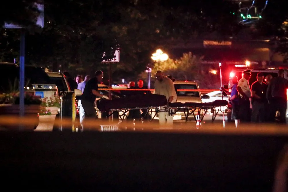 Bodies are removed from the scene of a mass shooting, Sunday, Aug. 4, 2019, in Dayton, Ohio. Several people in Ohio have been killed in the second mass shooting in the U.S. in less than 24 hours, and the suspected shooter is also deceased, police said. (AP Photo/John Minchillo)