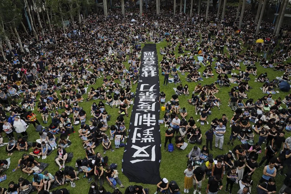 People gather at Belcher Bay Park as they take part in an anti-extradition bill protest in Western district in Hong Kong, Sunday, on Aug. 4, 2019. The banner reads "Against institutional violence, we want real elections." (AP Photo/Kin Cheung)